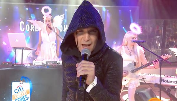 A hooded Corey Feldman doing terrible things on stage